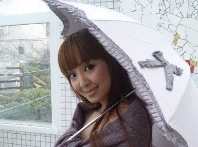 傘を差して微笑む神田うの（2010年）の画像