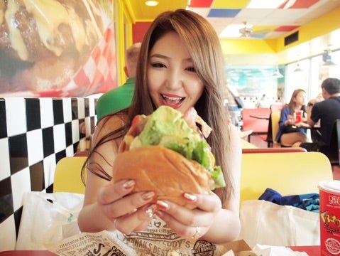 ハンバーガーを食べる大塚里香の画像